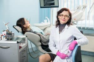 Portrait of friendly woman dentist with patient in the dental office. Dentistry